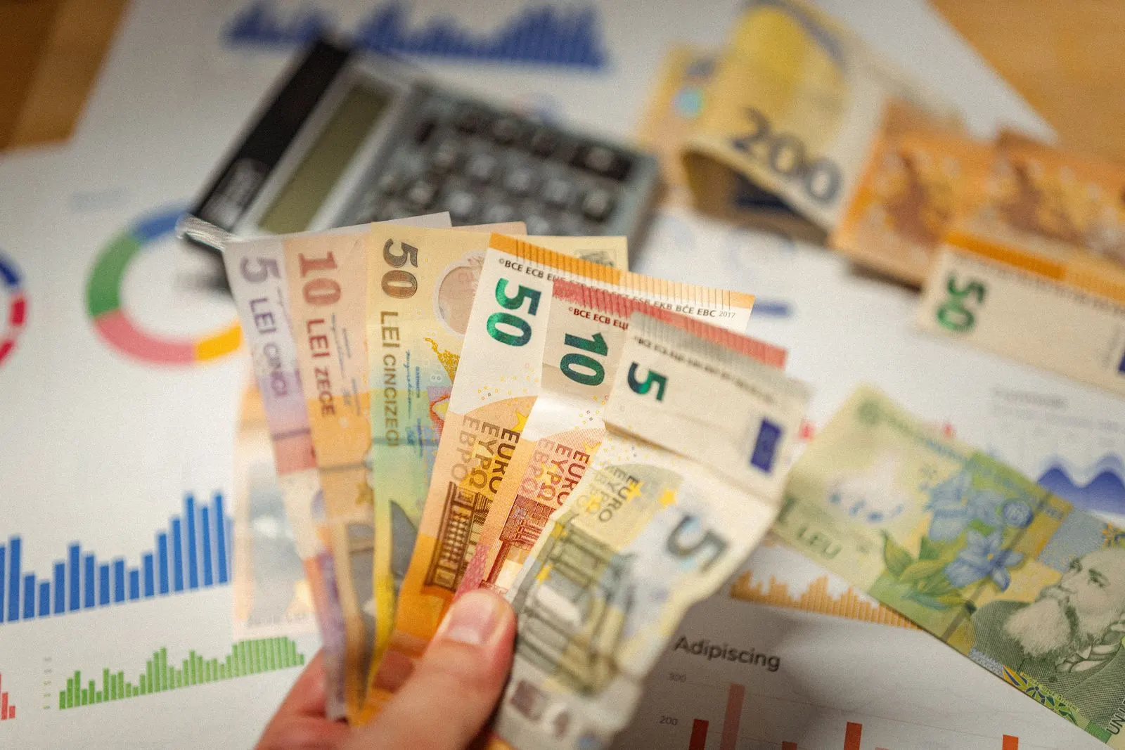 Aufgefächerte Euro-Scheine mit Taschenrechner