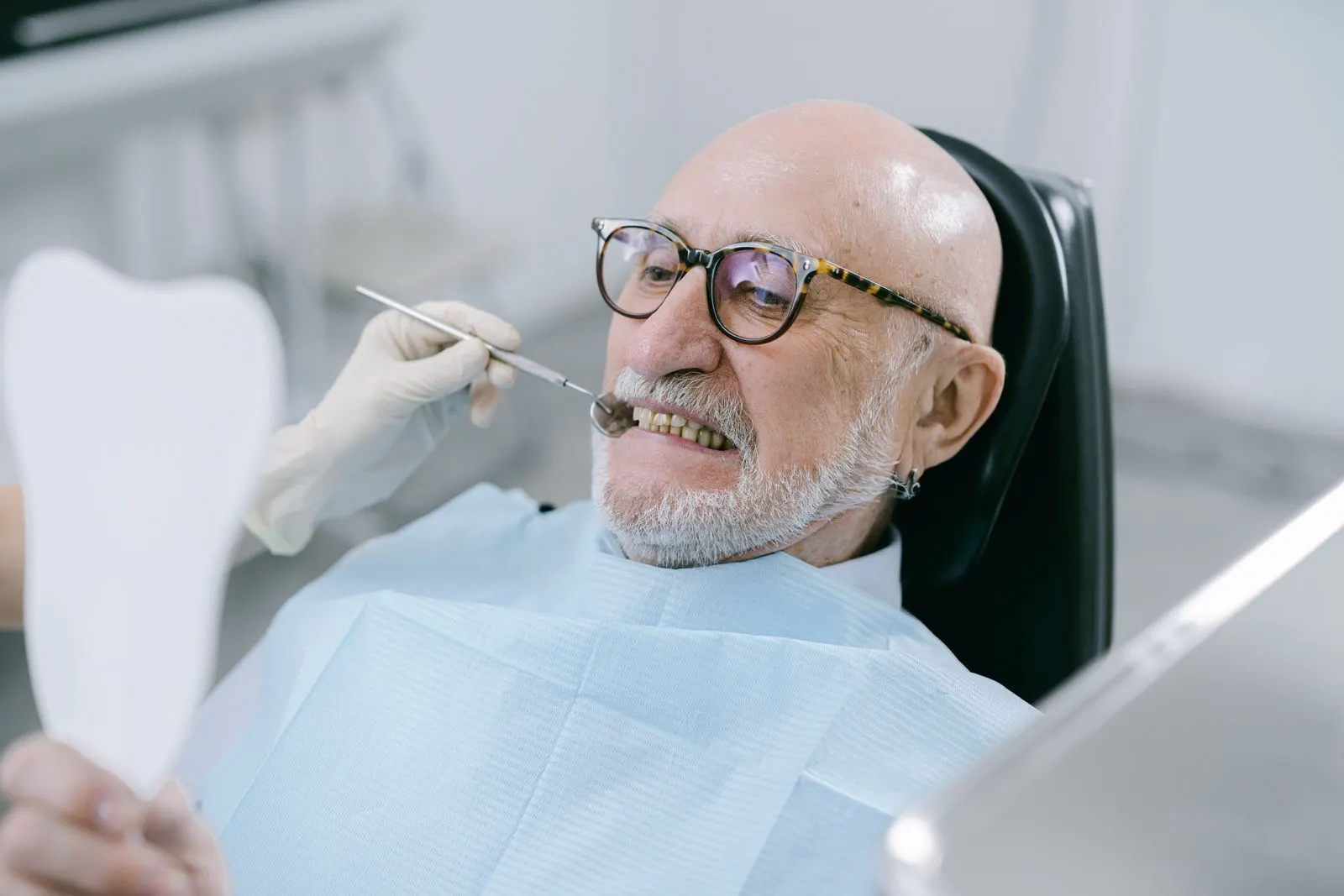 Man checking his teeth with a mirror